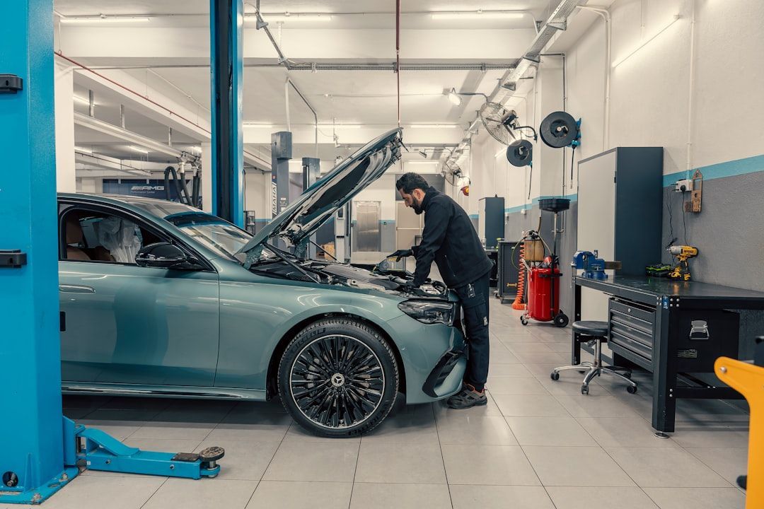 Auto mechanic inspecting a car engine in a repair shop, representing auto repair lead generation.