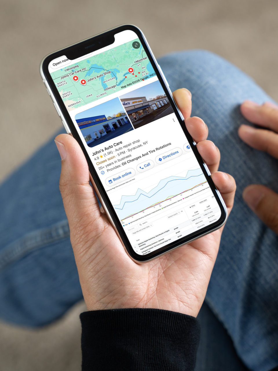 Hand holding a smartphone showing a travel map, photos, and a route preview.