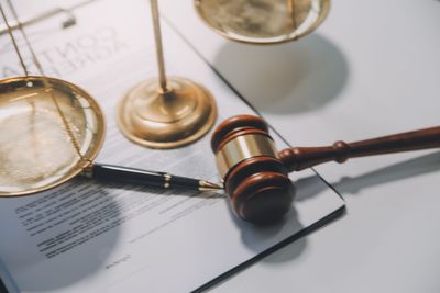 Law books and a judge’s gavel on a desk, with scales of justice in the background