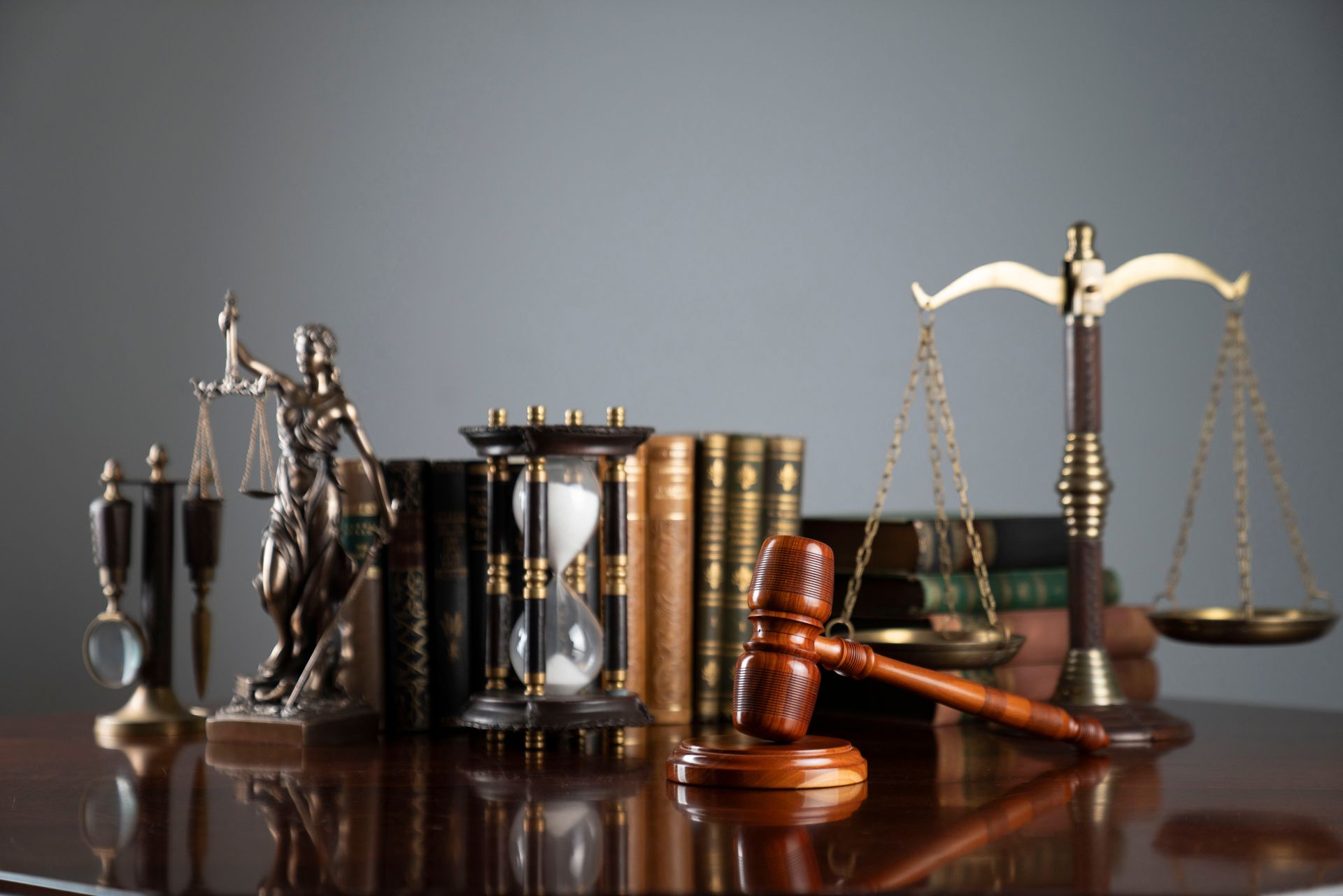 Law books, scales, gavel, and hourglass on a polished desk, symbolizing justice and law