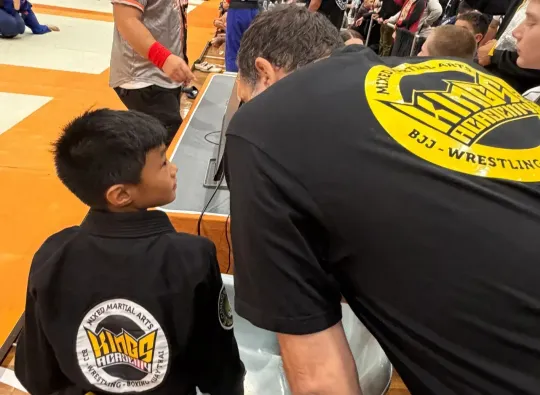 Elvis Sinosic coaching a student at Grappling Industries BJJ event