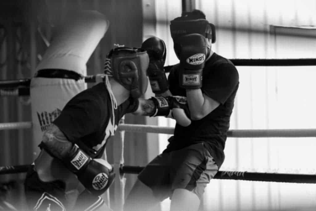 A black and white photo of two men boxing in a boxing ring