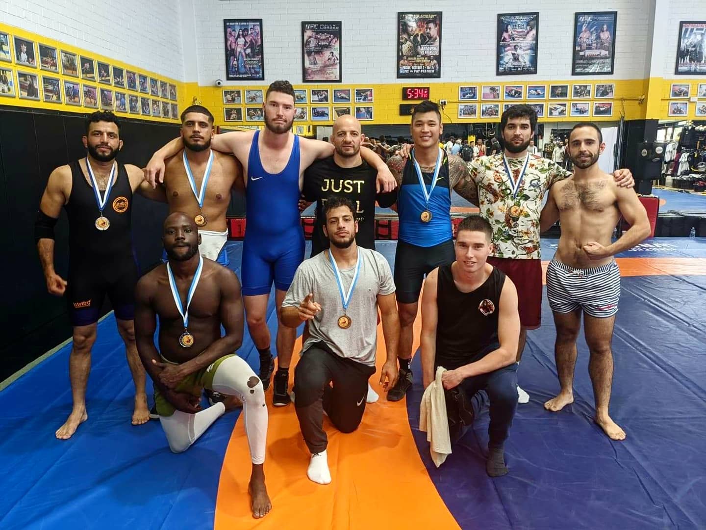 Group of medal-winning Kings Academy students on Wrestling mat at Kings Academy