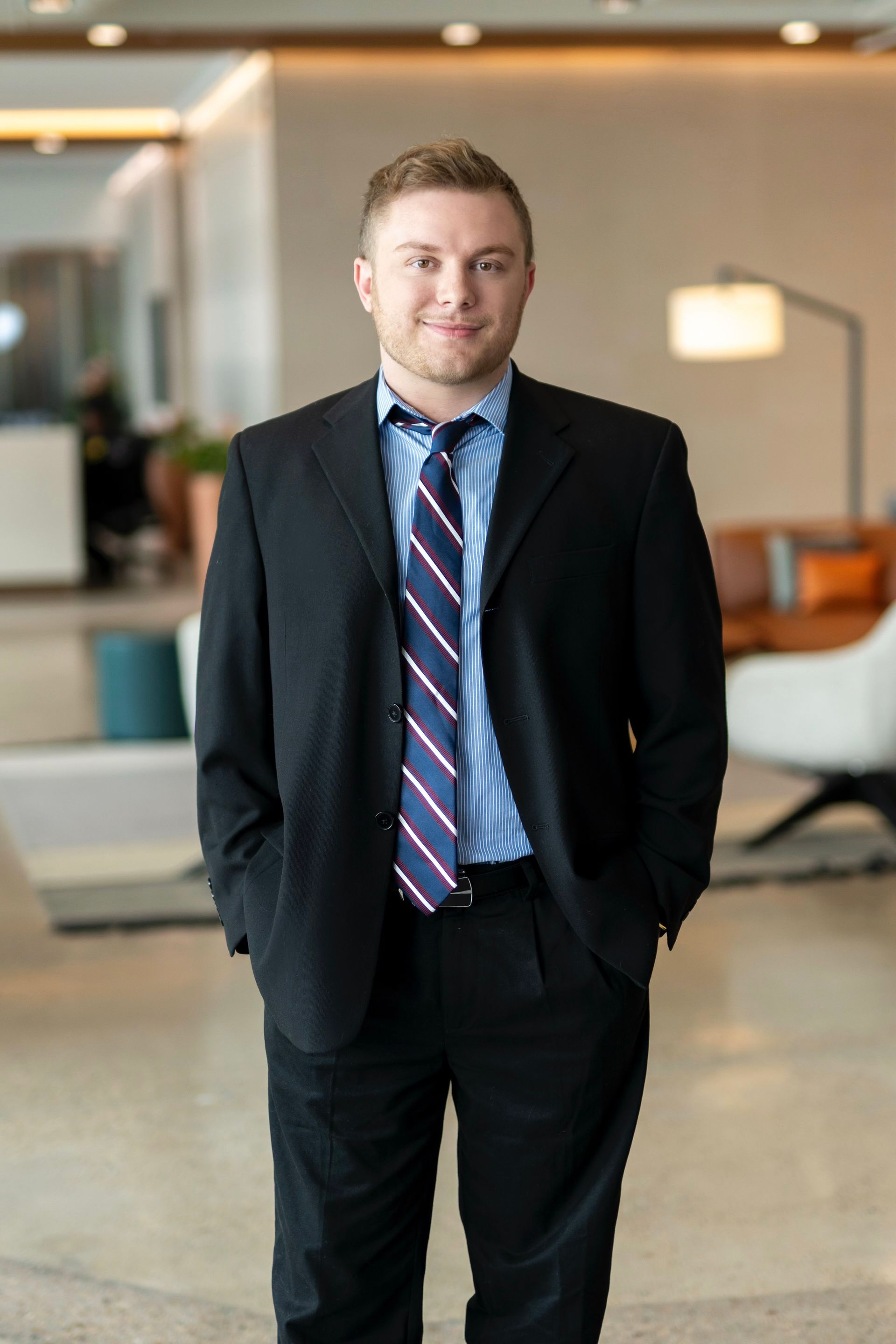 A man in a suit and tie is standing in front of a building.