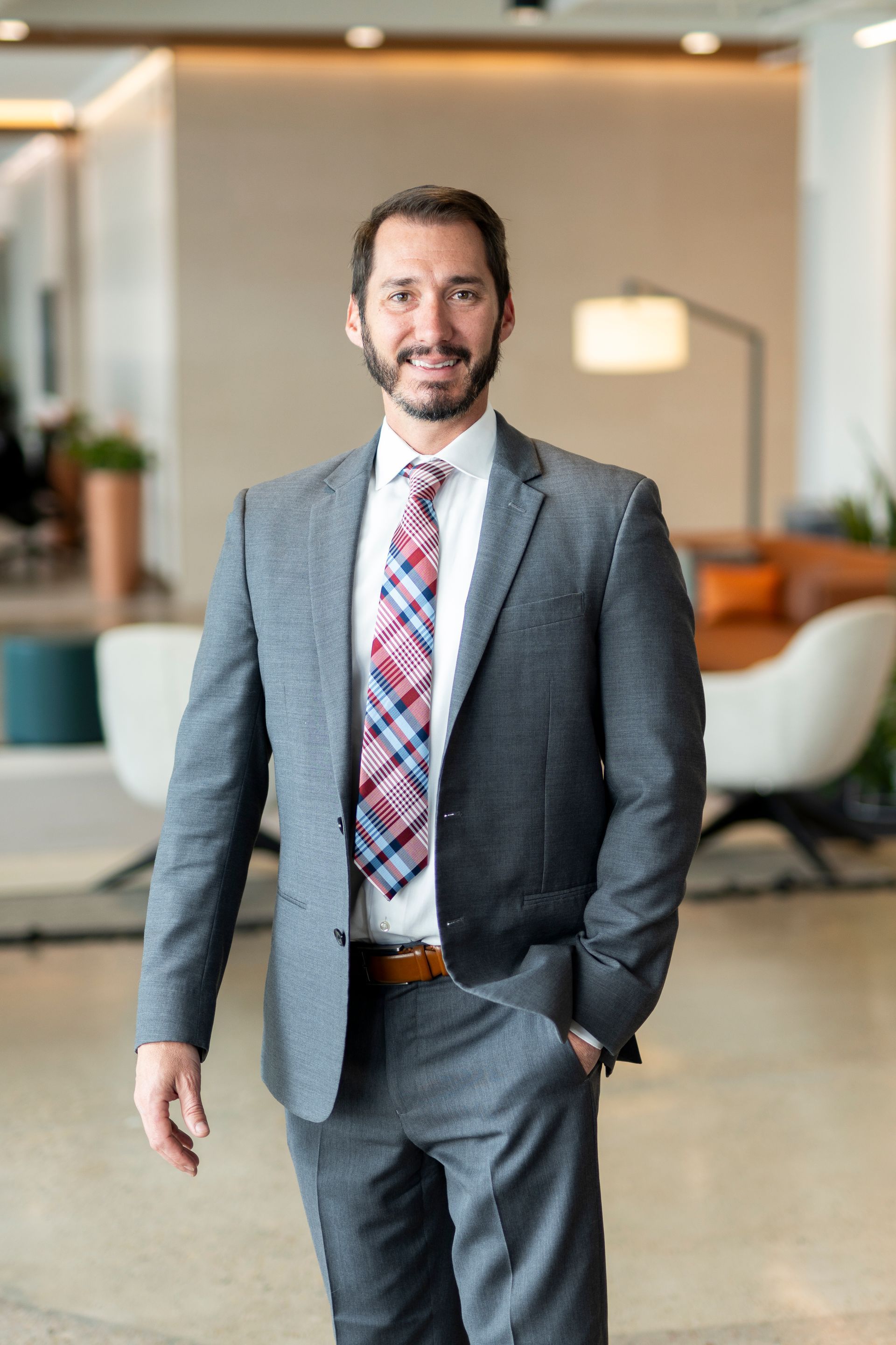A man in a suit and tie is smiling for the camera.