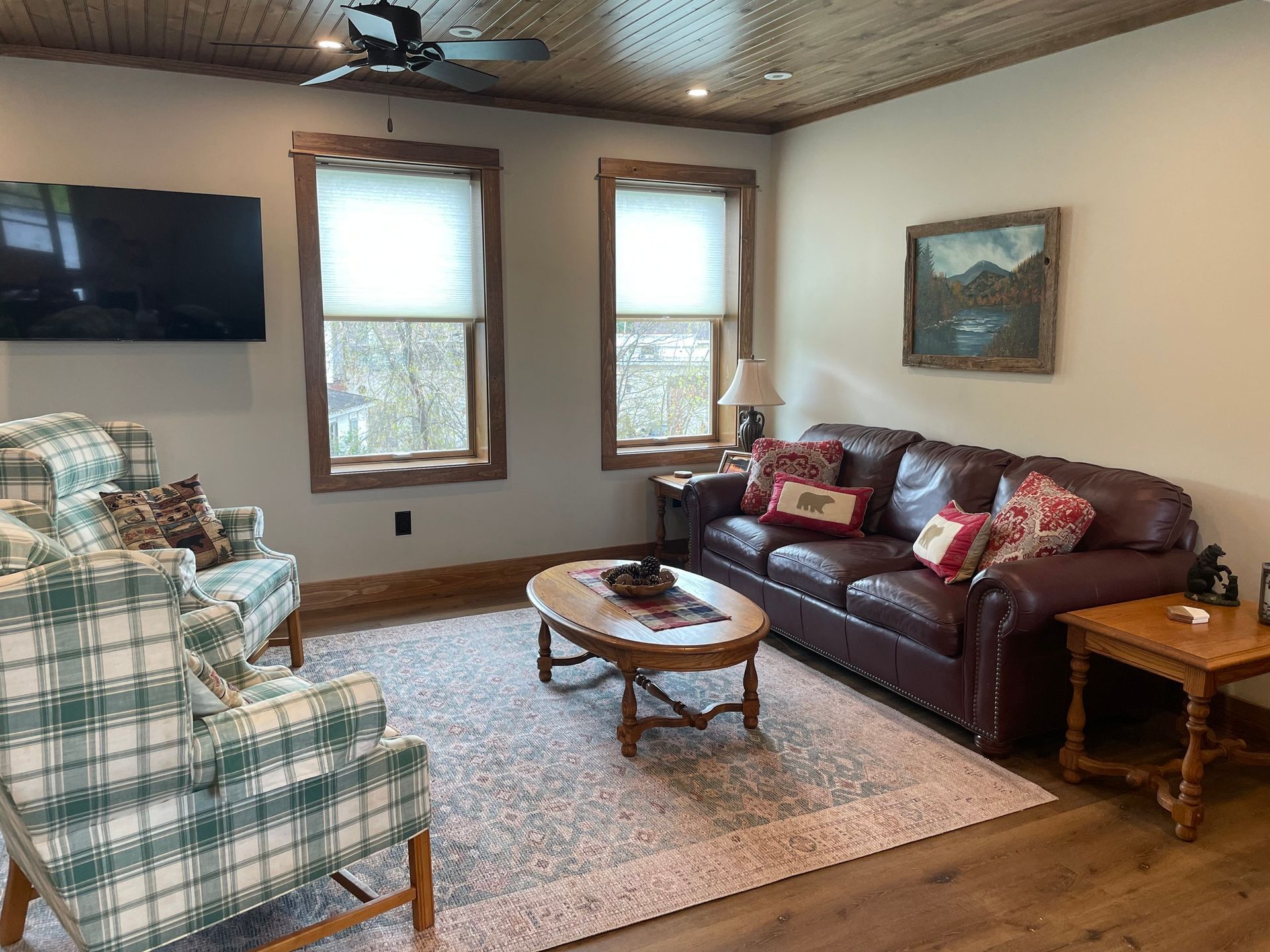 A living room with a couch , chairs , coffee table and television.