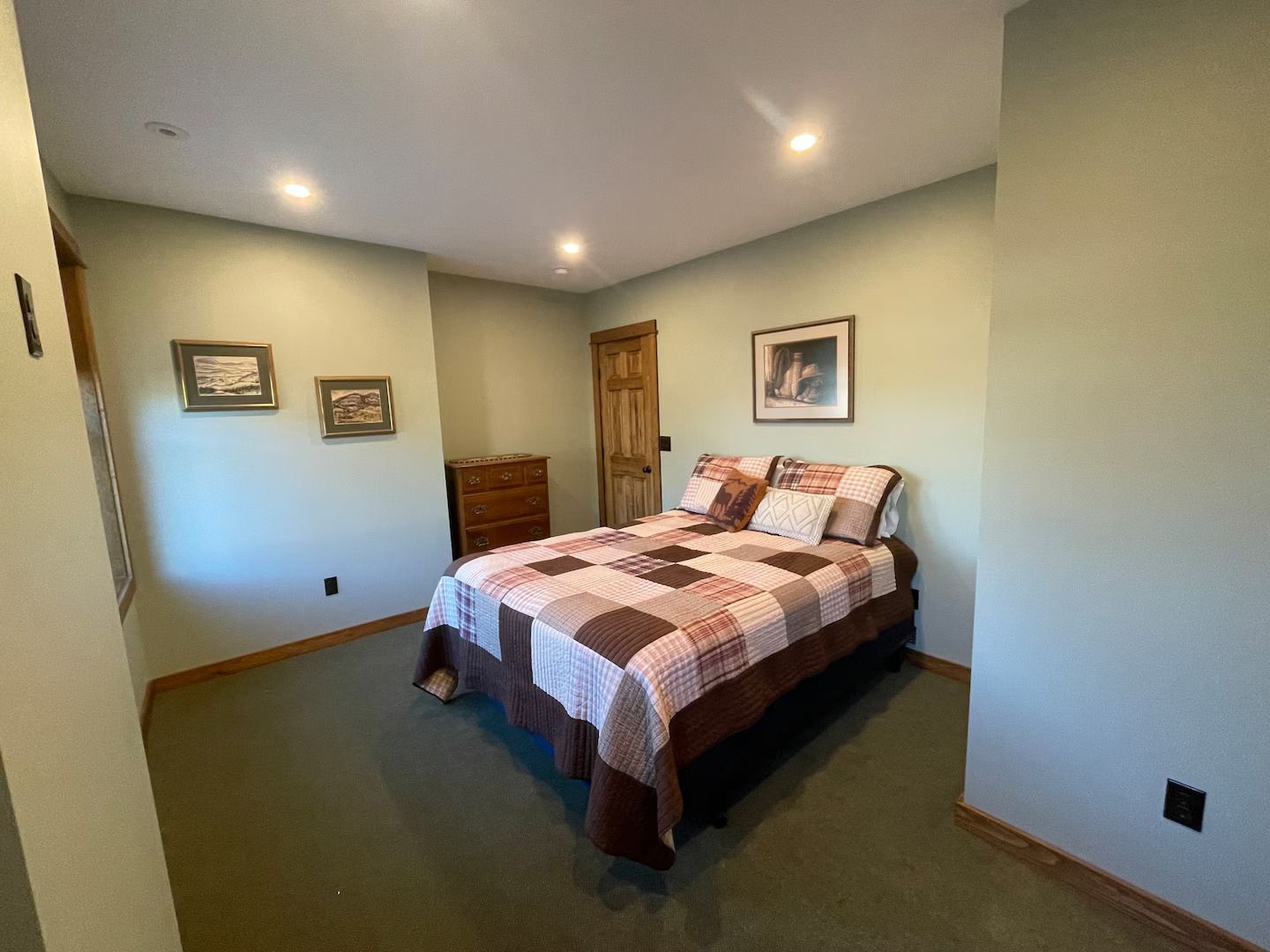 A bedroom with a large bed and a dresser.