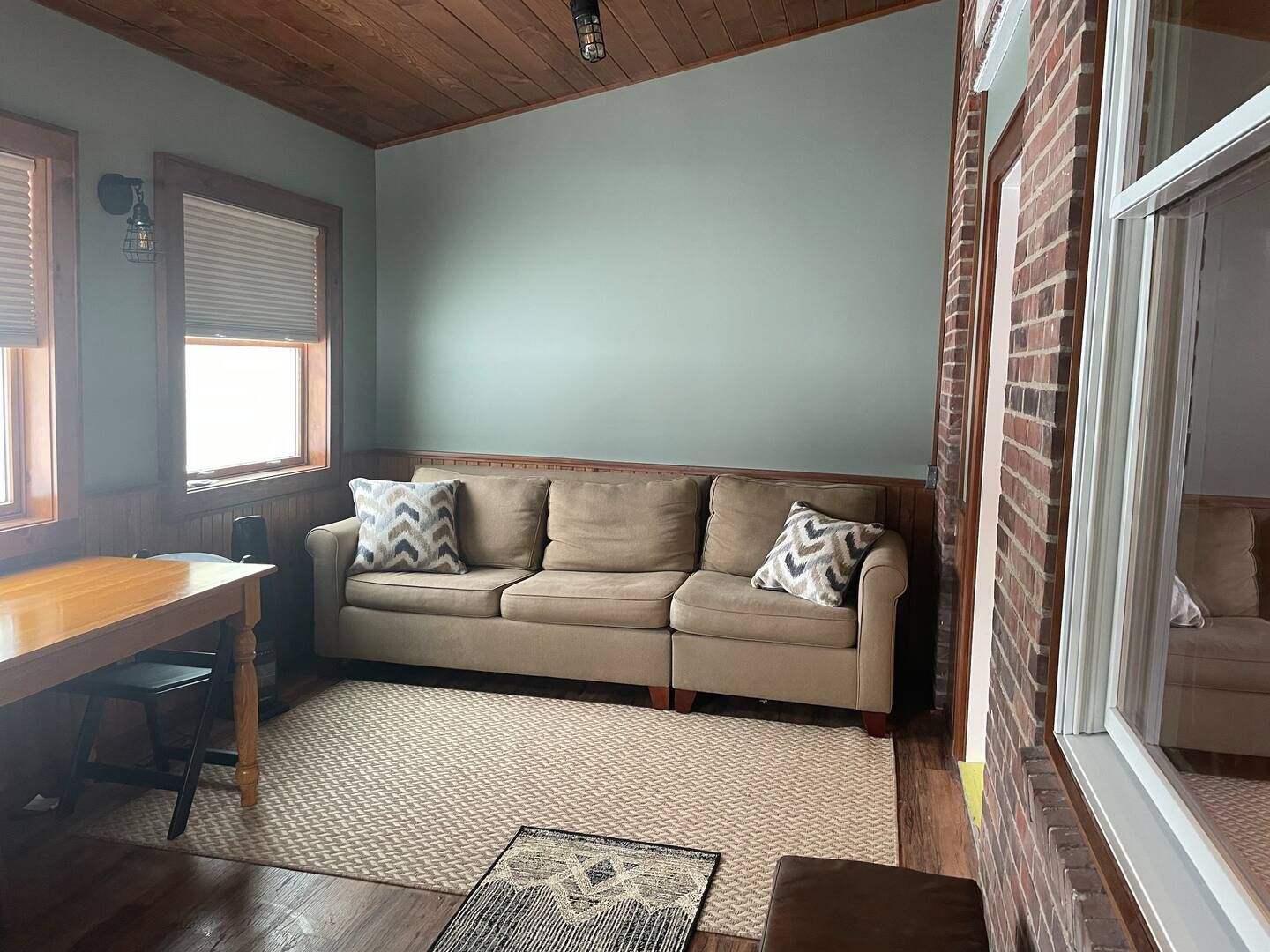A living room with a couch , table and window.
