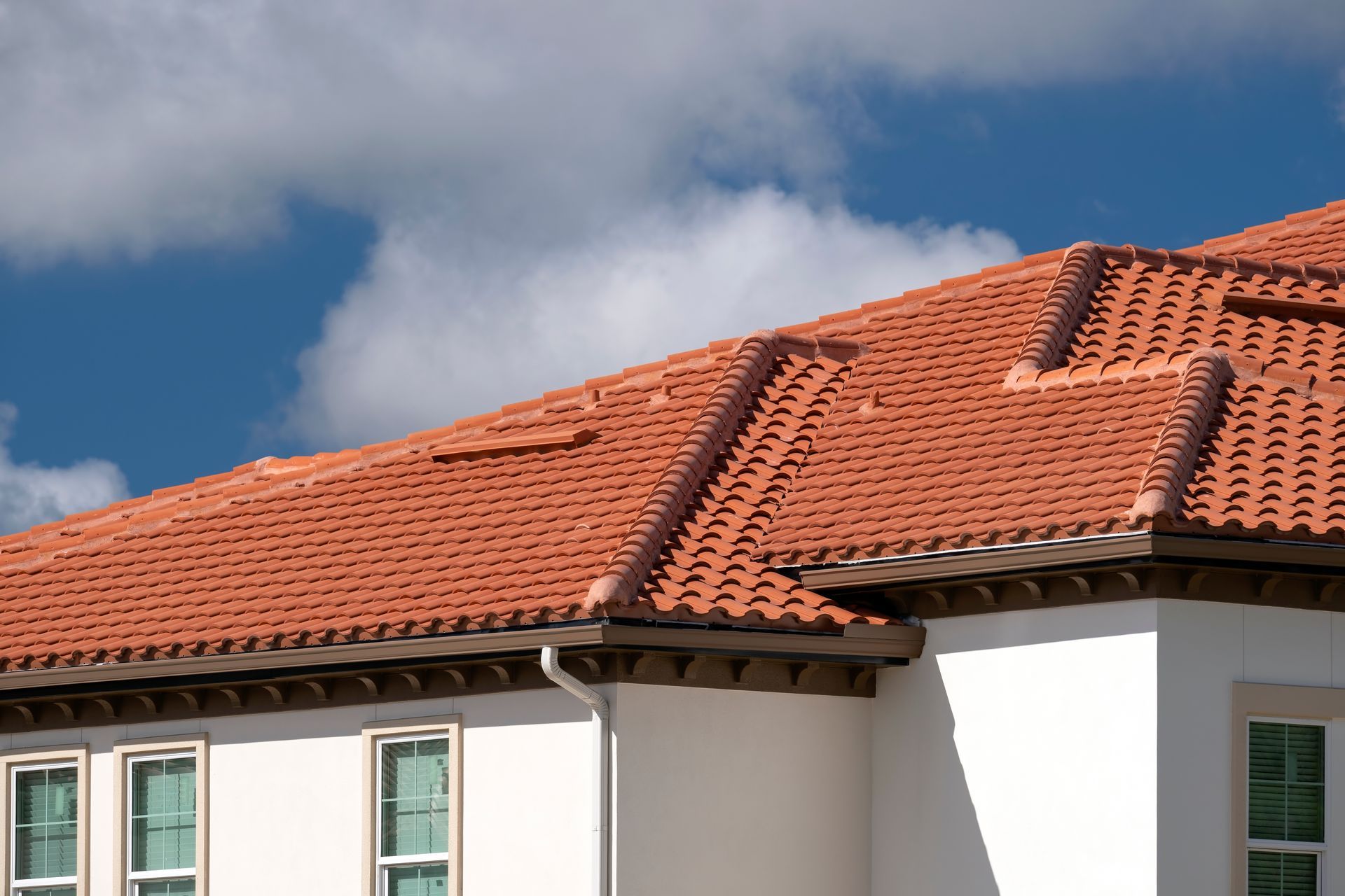White house with a red tiled roof against a blue sky