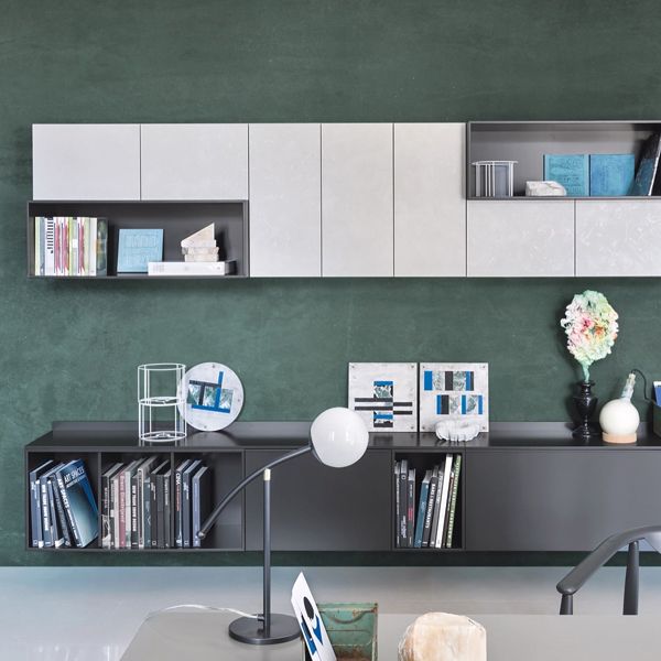Una habitación con una pared verde y un estante con una lámpara y un libro que dice 'stefan'