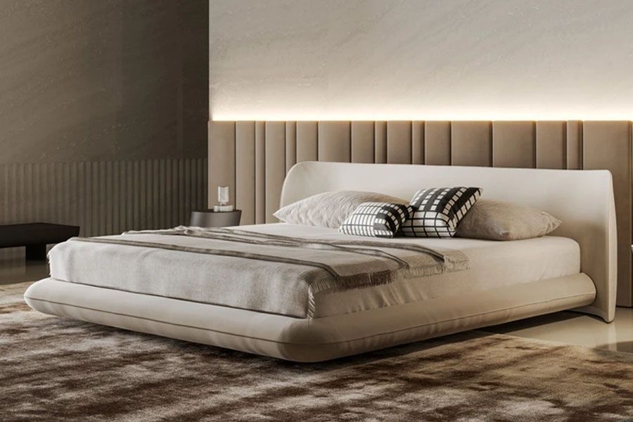 Un dormitorio con una cama con cabezal tapizado y sábanas blancas