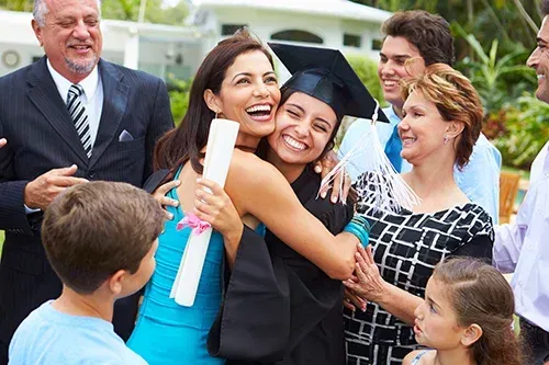 Woman and daughter at graduation surrounded by family