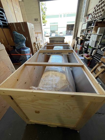 A large wooden box is sitting in a warehouse. Timely relocation services