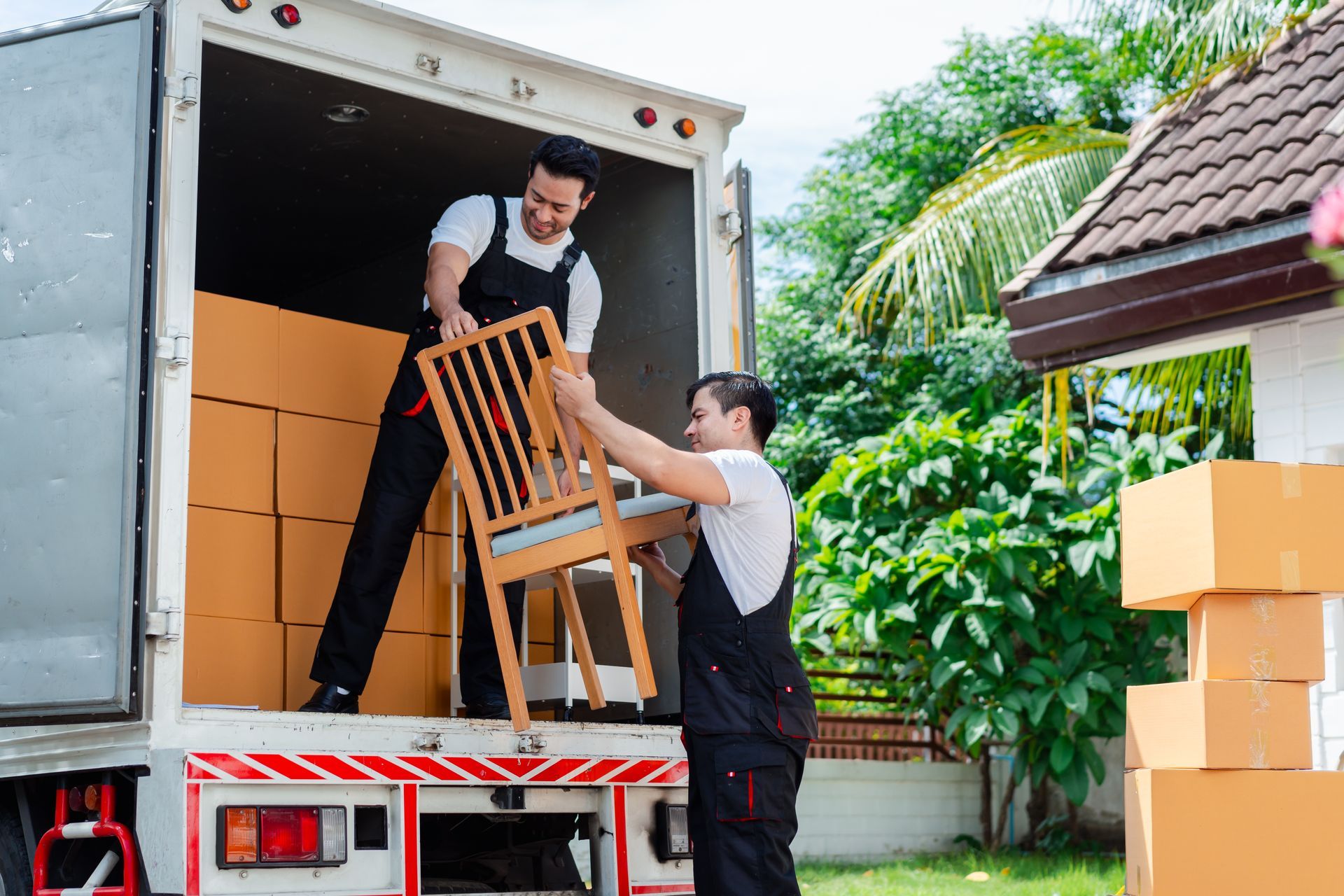 Two men are loading a chair into a moving truck. Expert, timely and safe furniture movers.