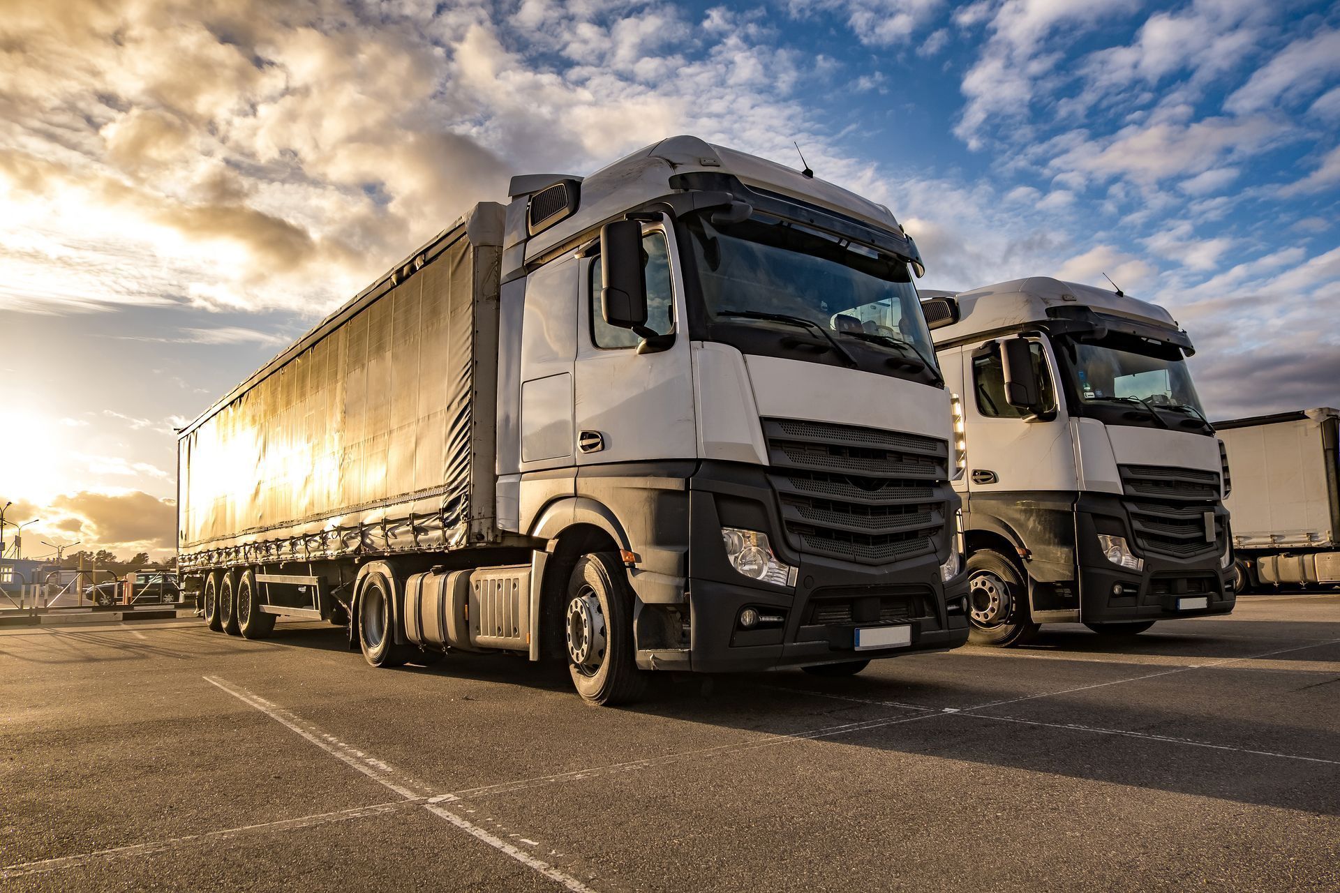 Two semi trucks are parked next to each other in a parking lot. Professional, time-saving cross-country movers.