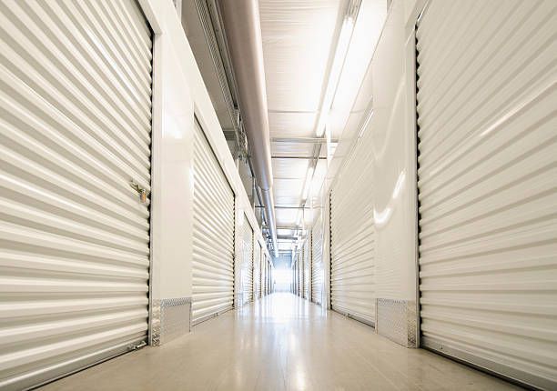 Interior view of a row of clean, organized storage units with shelves and boxes for storage needs | 