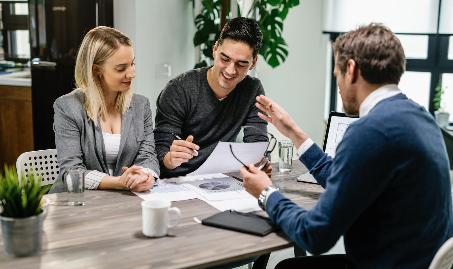Un homme et une femme sont assis à une table et parlent à un homme.