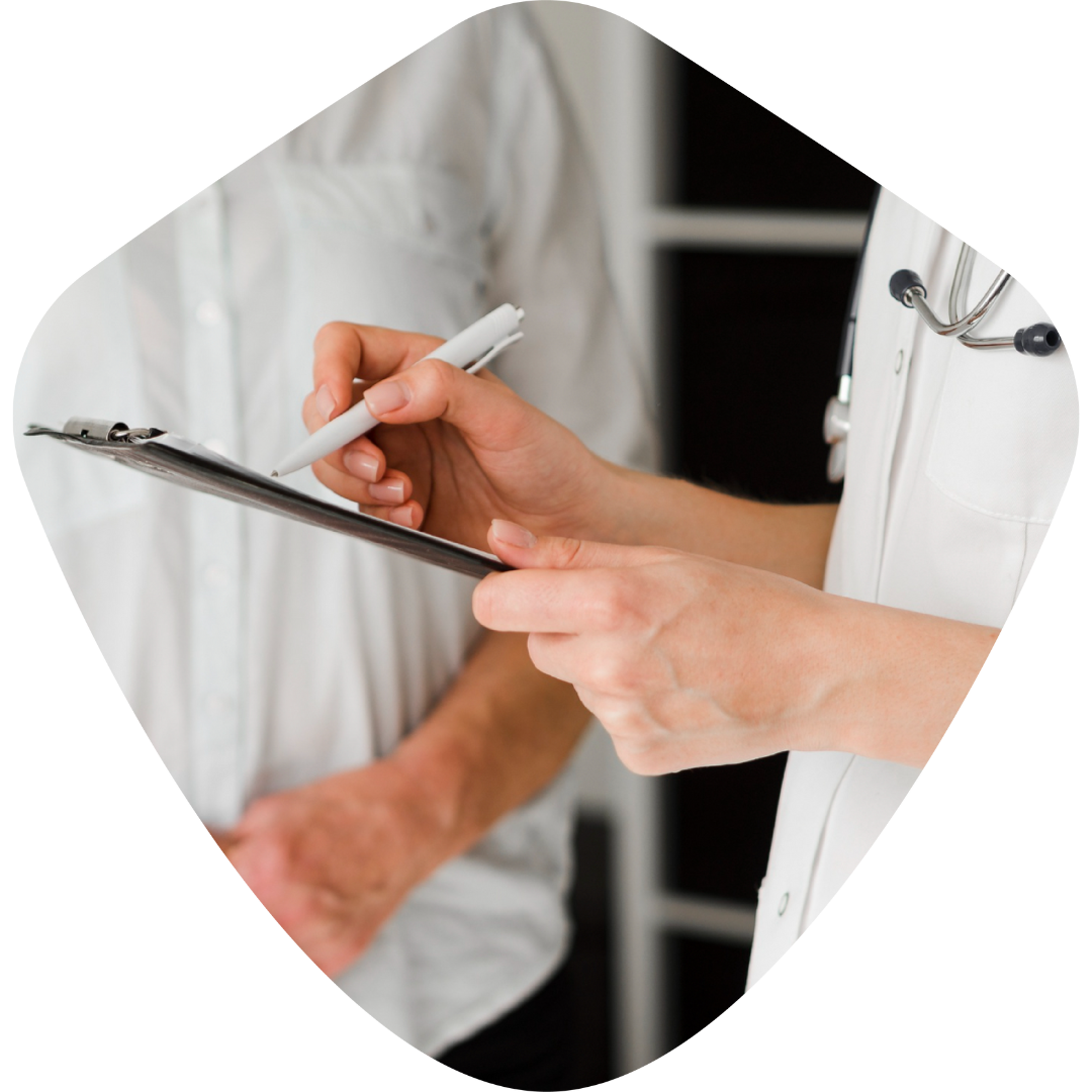 Un médecin écrit sur un presse-papiers pendant qu'un patient regarde.