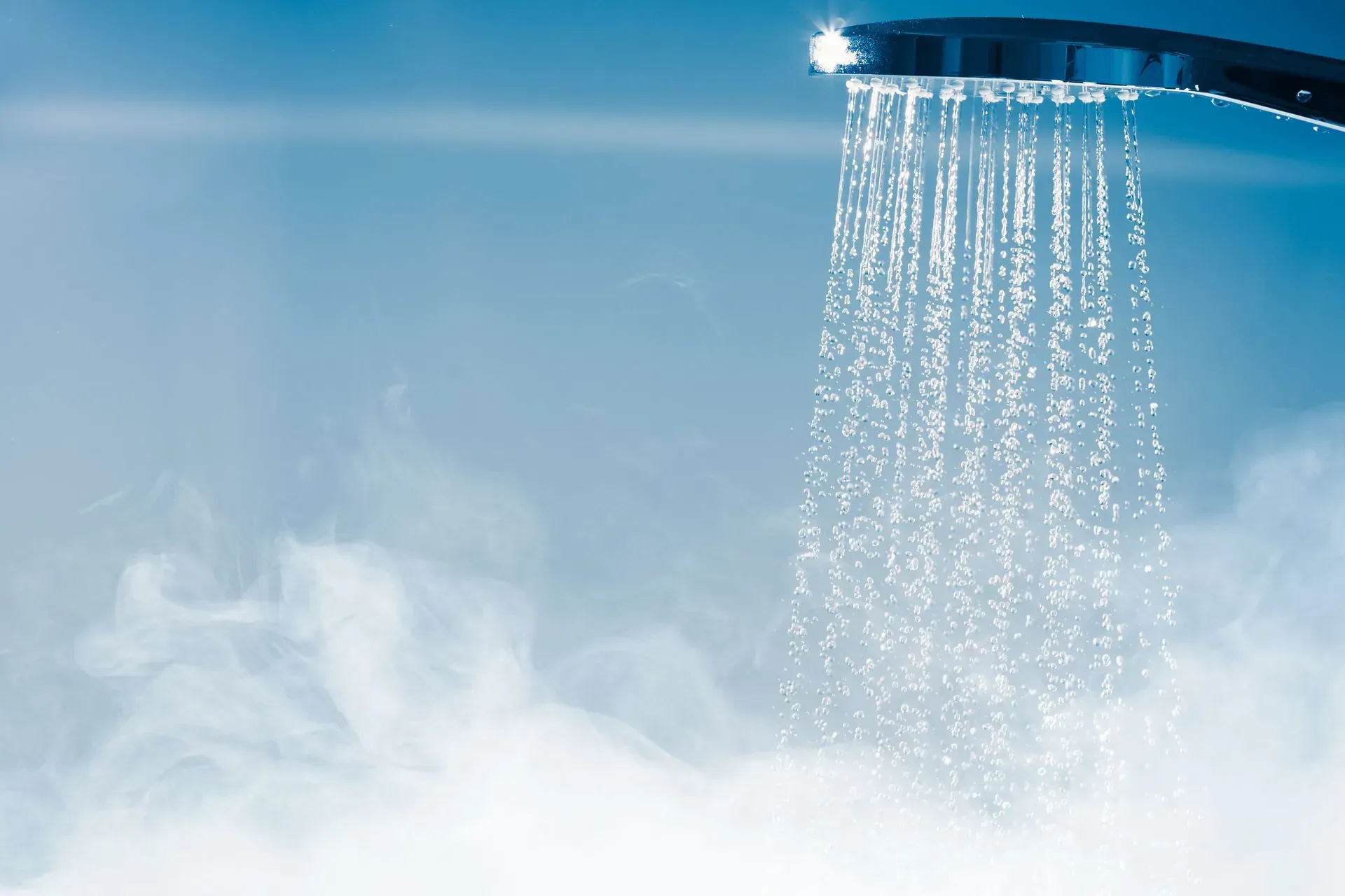 A close up of a shower head with water coming out of it.