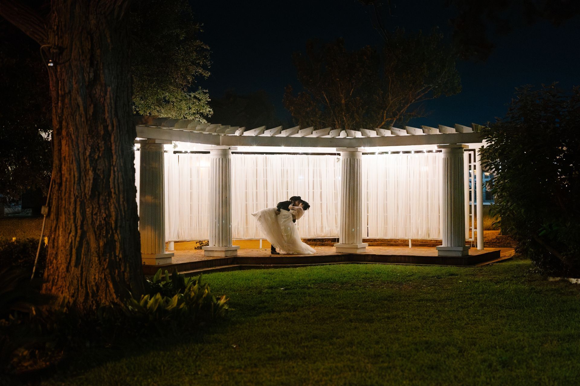 wedding couple kissing at the garden ceremony alter at Ant Street Inn in Brenham, tx