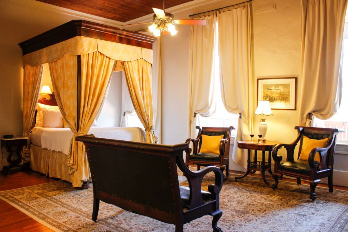 There is a canopy bed in the middle of the room.