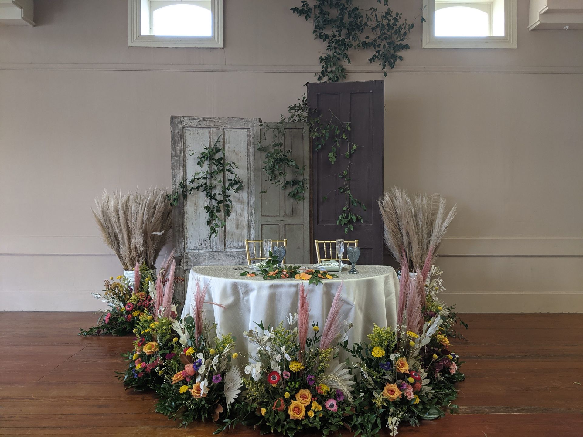 There is a table with flowers on it in the middle of the room.