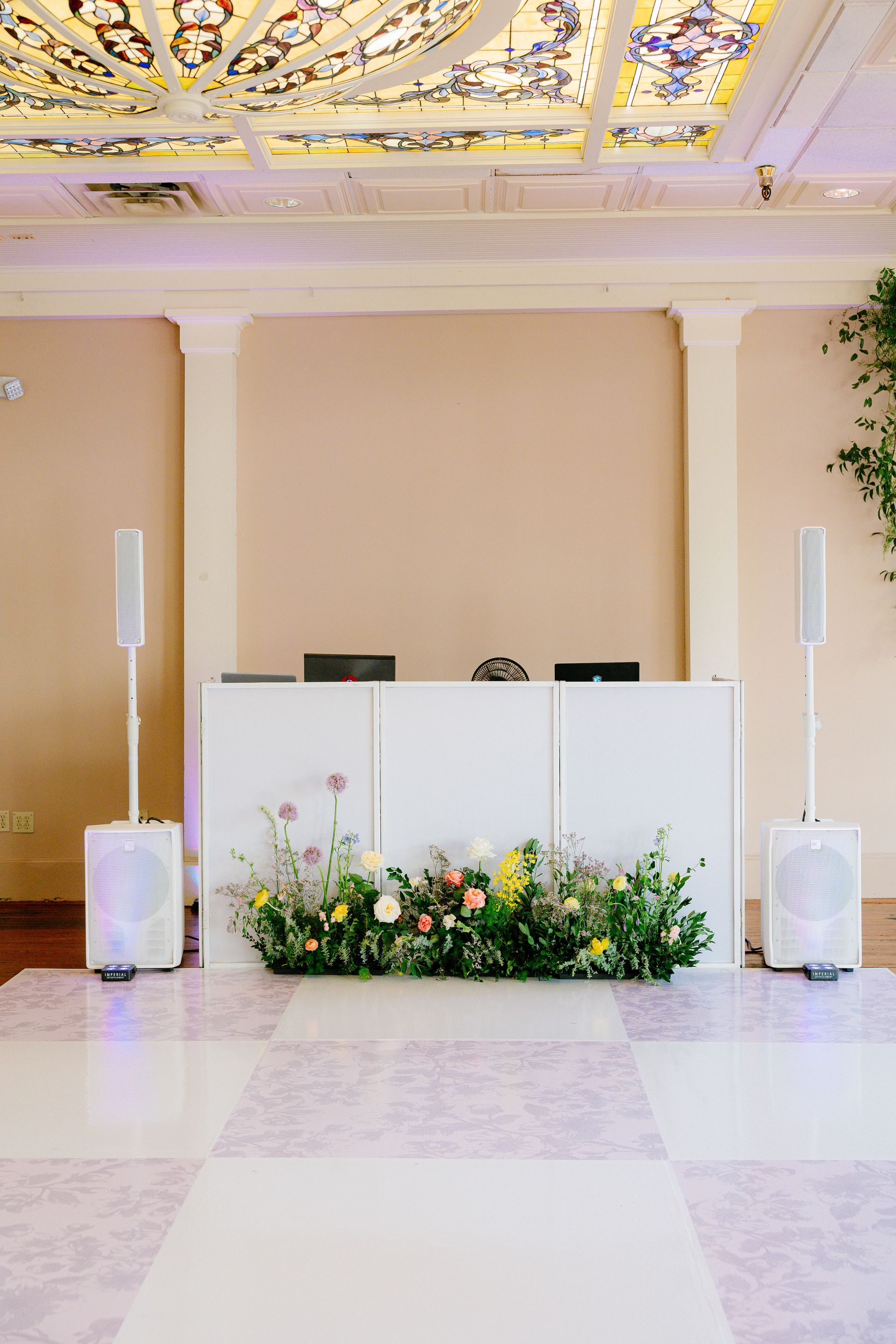 Dj booth with flowers and speakers at a hotel ballroom in Ant Street Inn