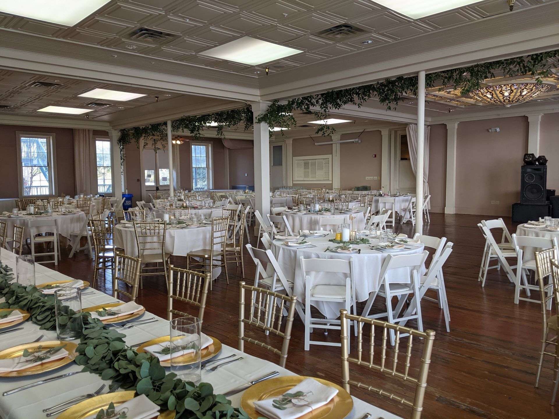 A large room with tables and chairs set up for a wedding reception.
