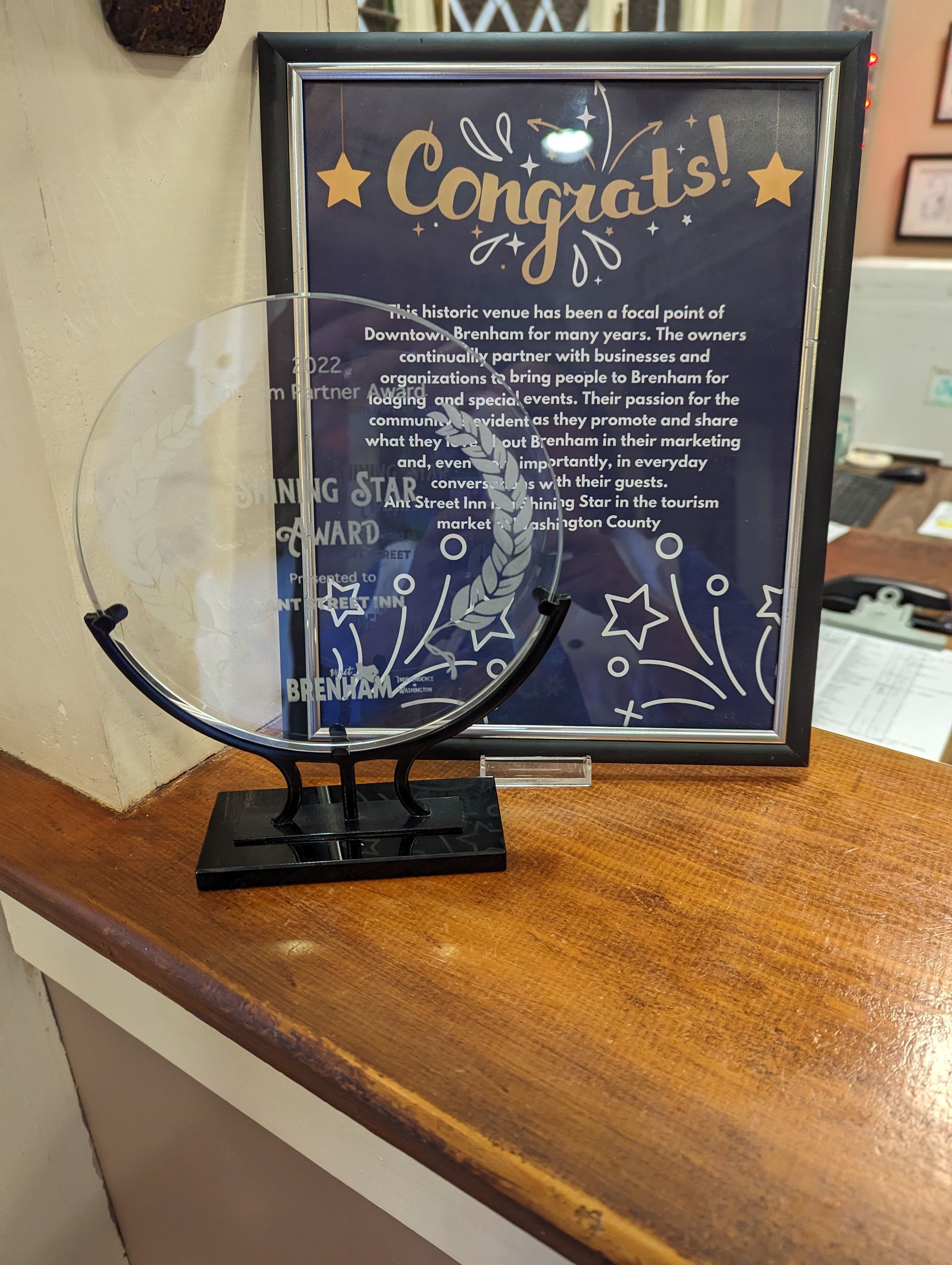 Award plaque on a wooden counter next to a framed 