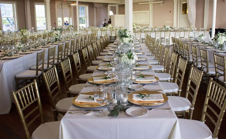 A large room filled with tables and chairs and a buffet table.