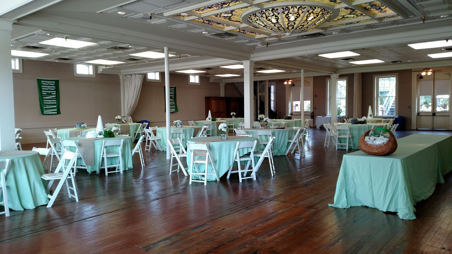 A large room with tables and chairs set up for a wedding reception.