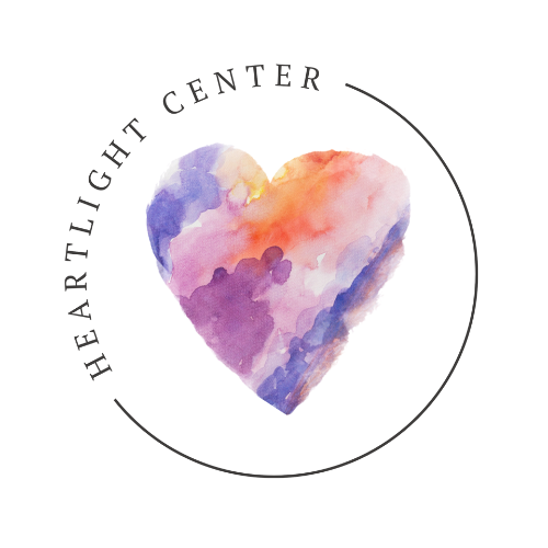 Heartlight Center logo with a watercolor heart in purple, pink, and peach inside a thin circular outline.