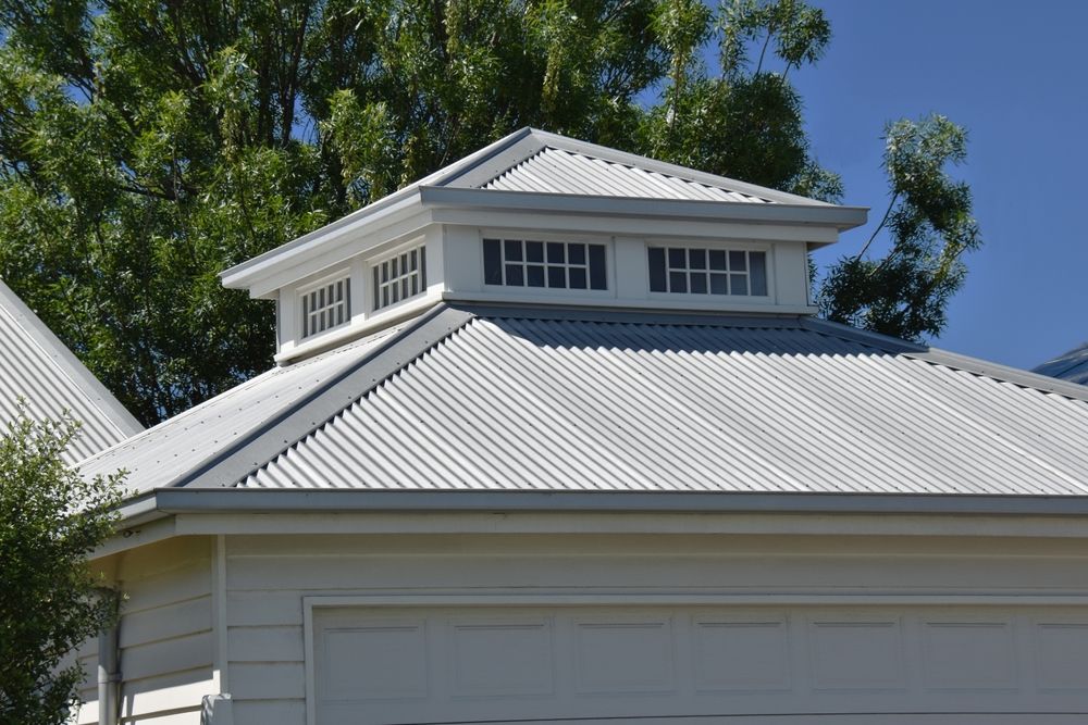 White Garage With Corrugated Metal Roof and a Cupola With Small Windows — GCX Roofing In Coomera, QLD