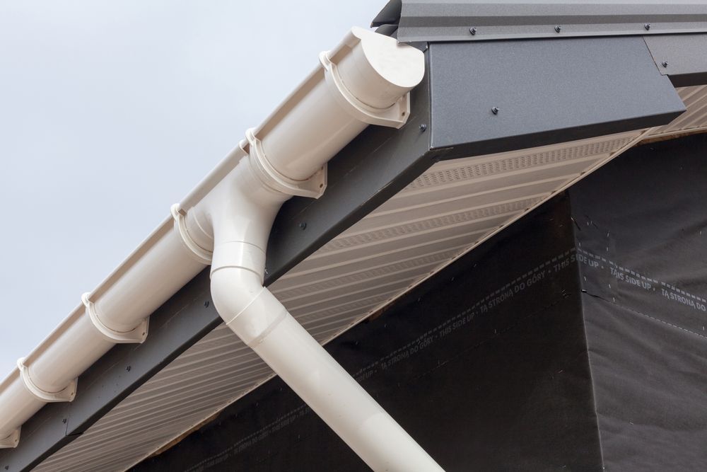 Beige Gutter and Downspout on a Roof Corner — GCX Roofing In Ipswich, QLD