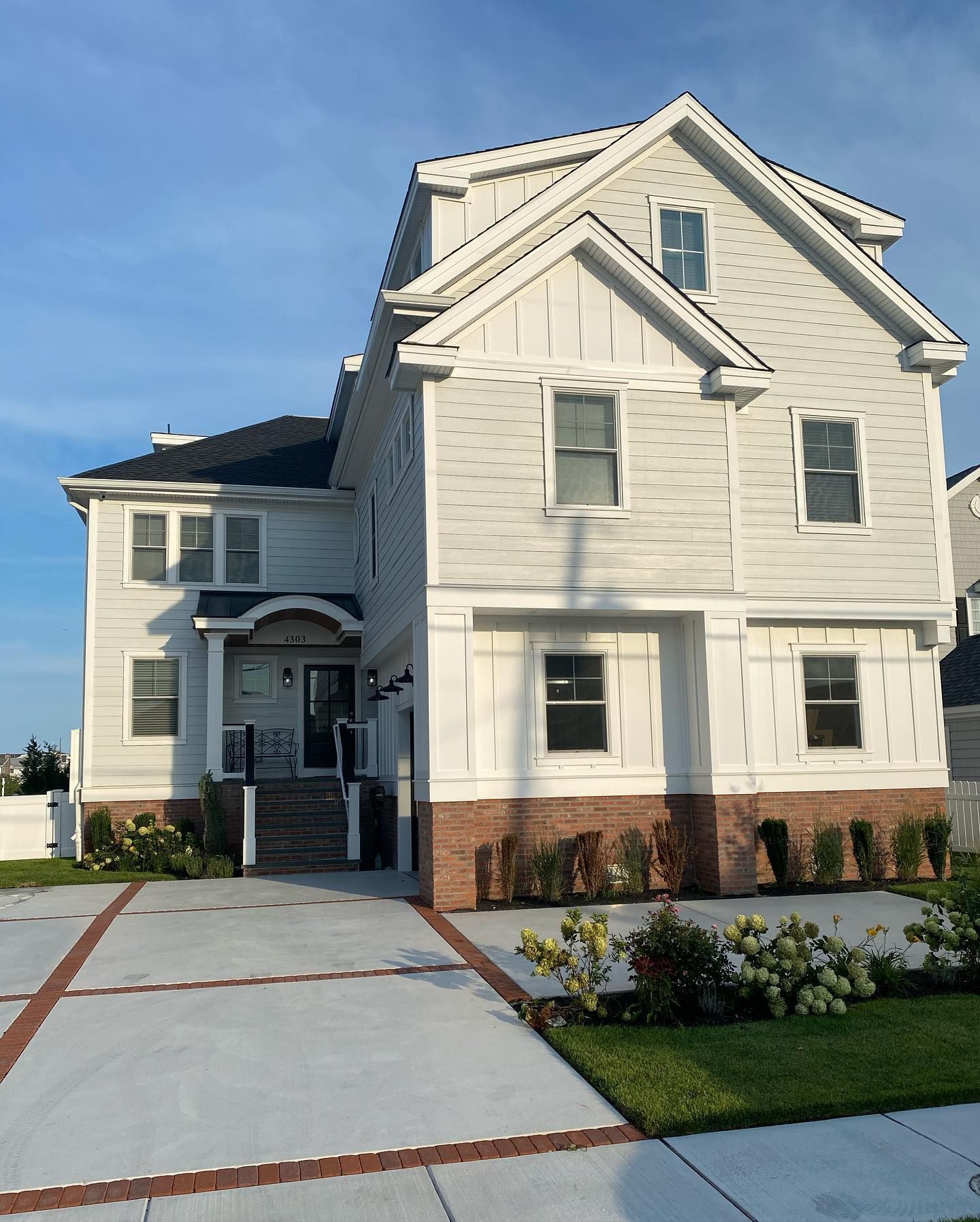 Three-story light gray house with brick facade and concrete driveway in sea isle city, nj built by j.k. construction llc