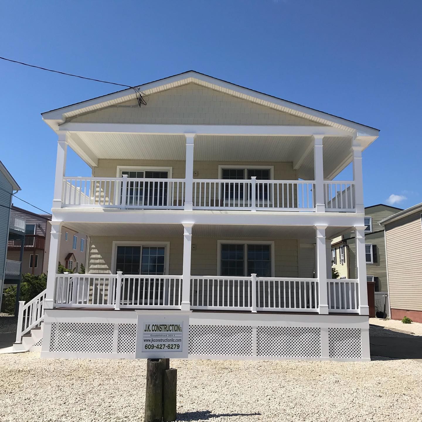 Exterior remodel of a shore house with tan siding, white pillars and decking in avalon, NJ done by J.K. Construction LLC of Cape May Court House, NJ