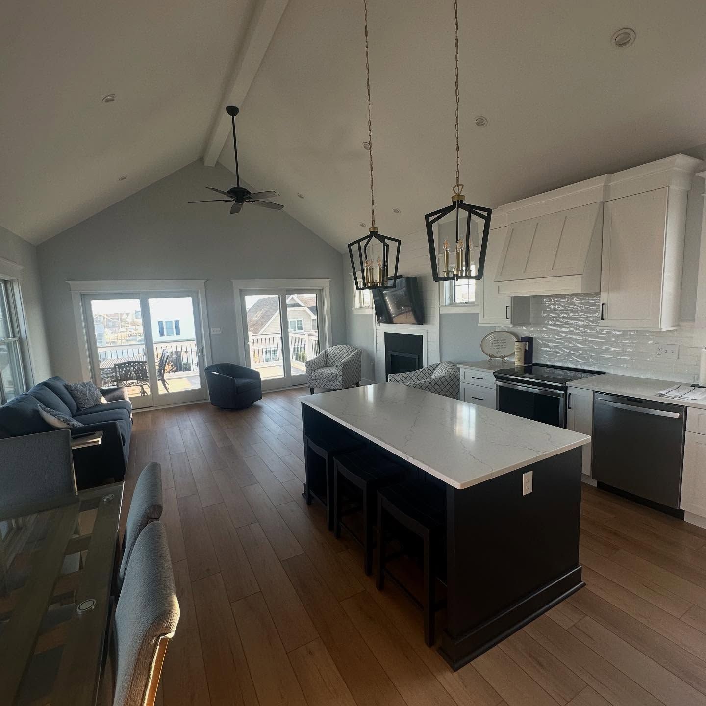 Spacious open-concept kitchen and living area with island, hardwood floors, and a view of the outdoors remodeled by j.k. construction llc in strathmere, new jersey