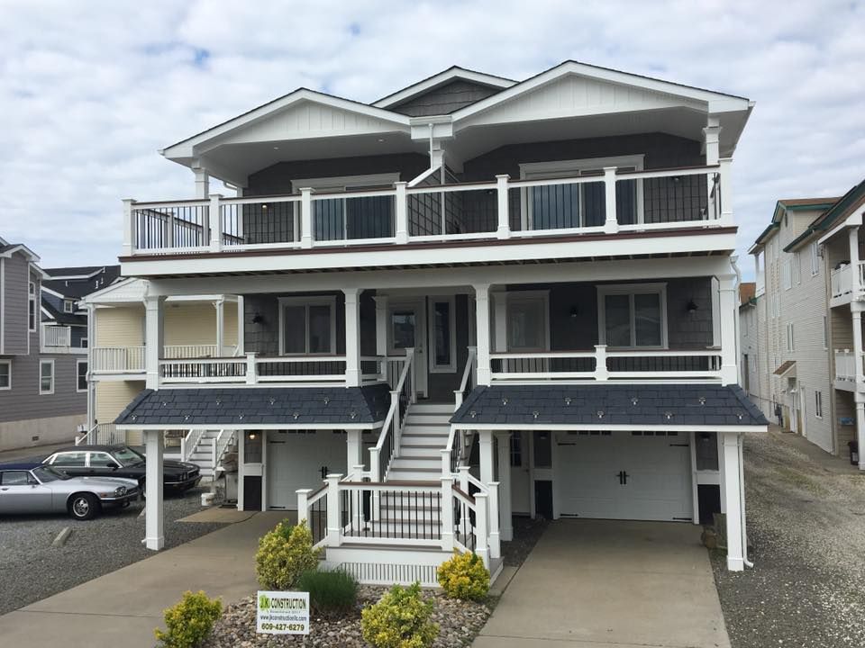 Exterior remodel of a shore house with grey siding, white pillars and garage door in Cape May, NJ done by J.K. Construction LLC of Cape May Court House, NJ