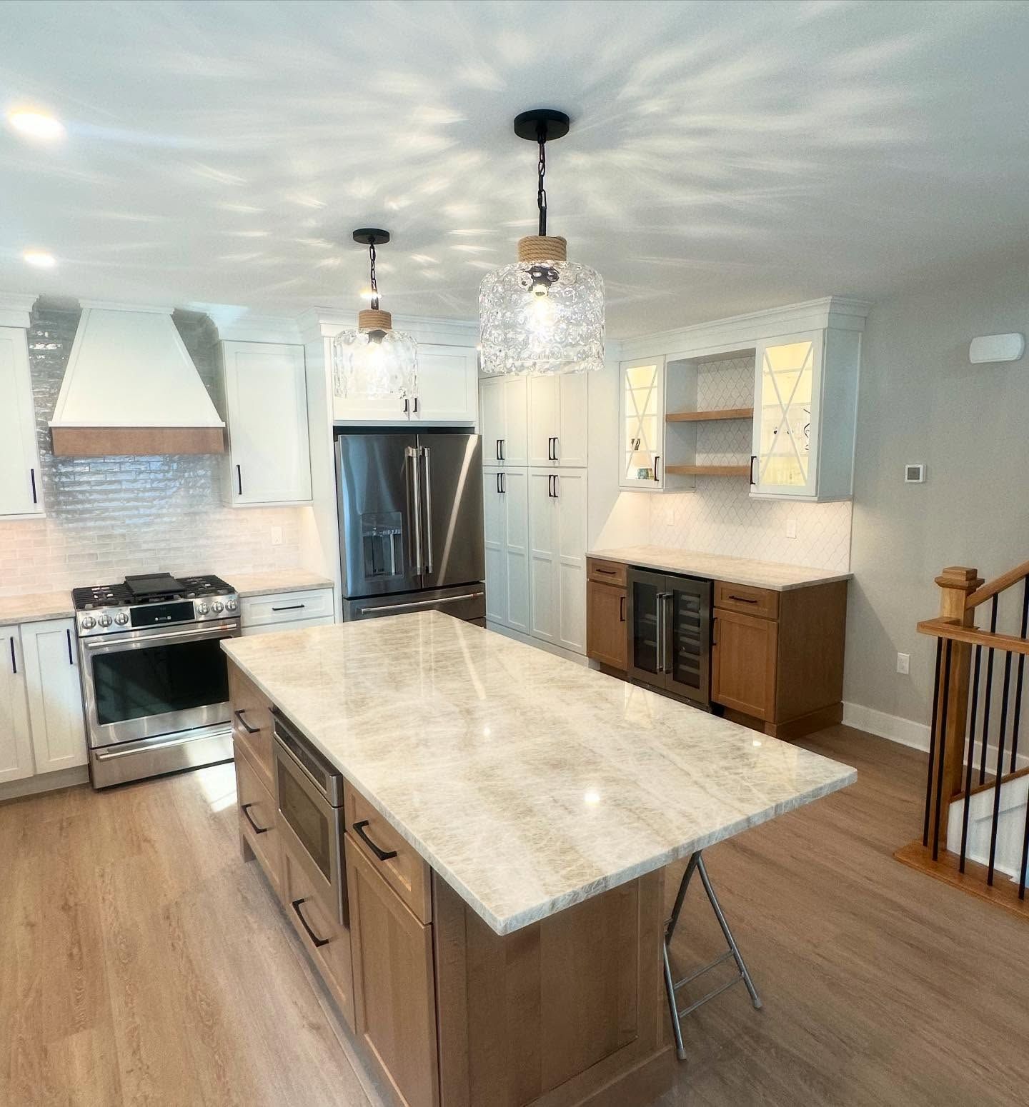 A remodeled modern kitchen with cream cabinets, a wooden island, stainless steel appliances, and pendant lights done by j.k. construction llc