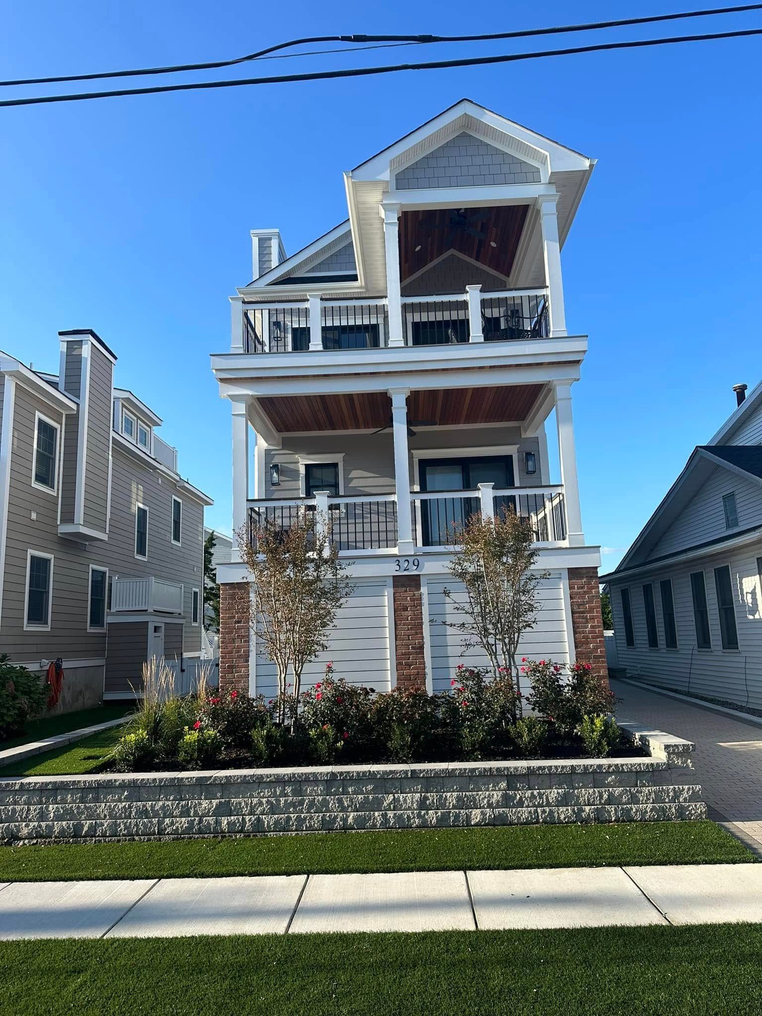 newly built two-story house with porch, gray siding, brick accents by j.k. construction llc in wildwood, new jersey