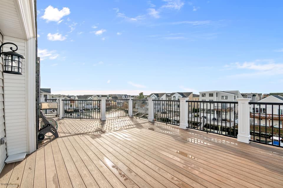 renovated wooden deck with black railing overlooking a neighborhood done by j.k. construction llc in avalon, new jersey