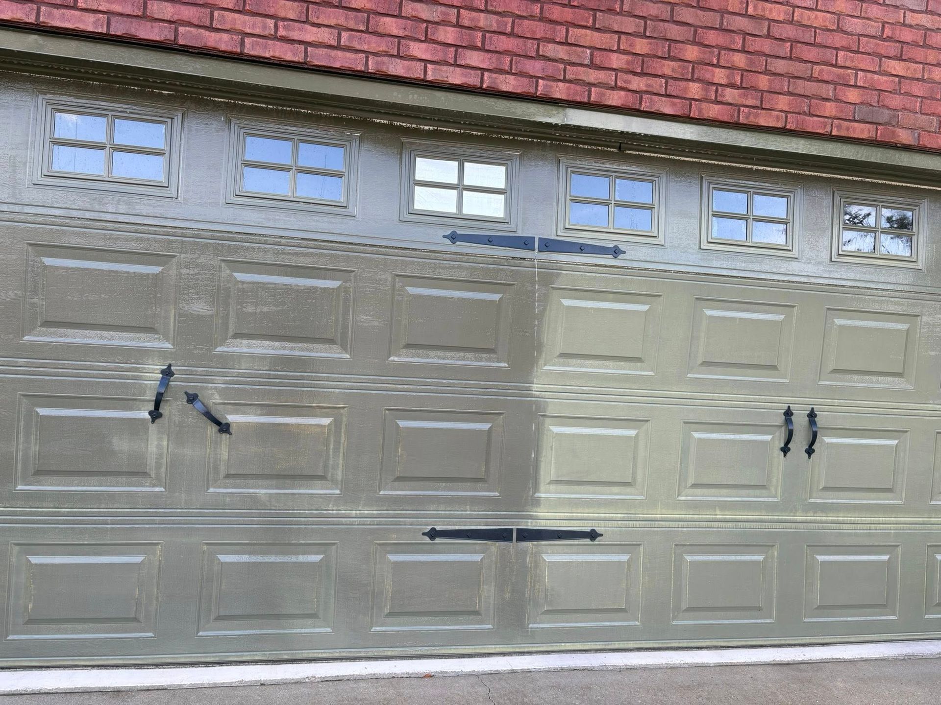 Garage door with rectangular panels and small windows at top.