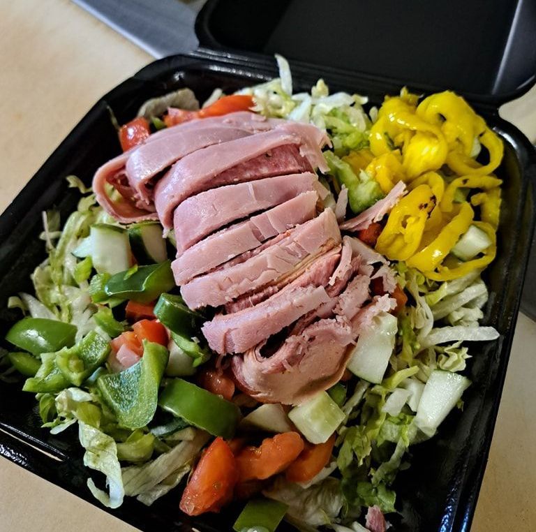 A black plastic container filled with meat and vegetables