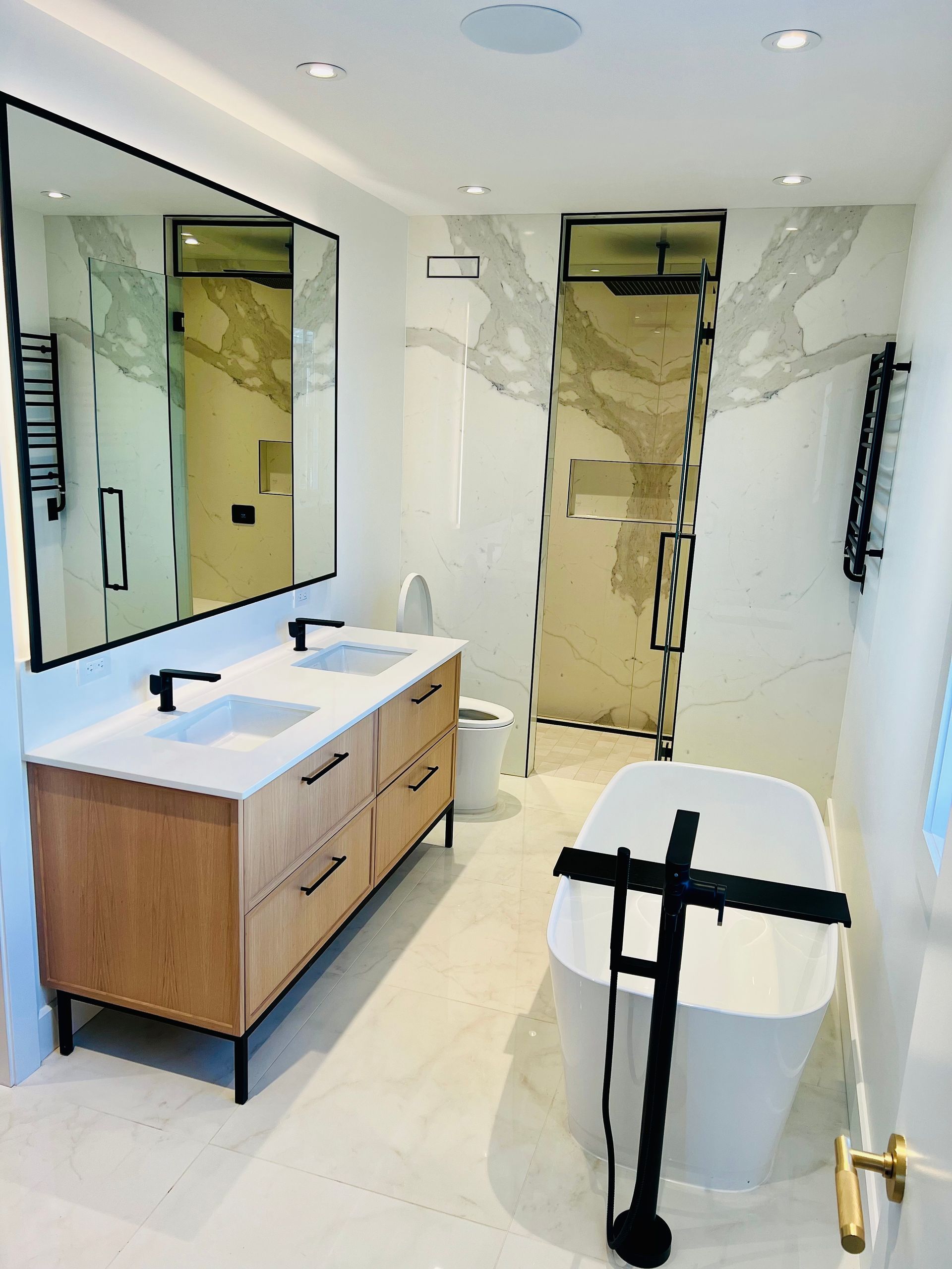 Une salle de bain avec deux lavabos, des toilettes et une baignoire