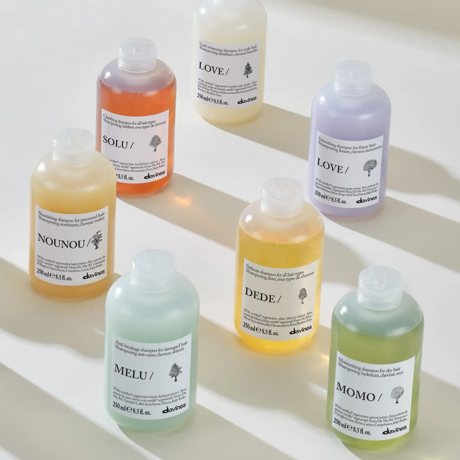 Three bottles of hair products are sitting on a wooden table.