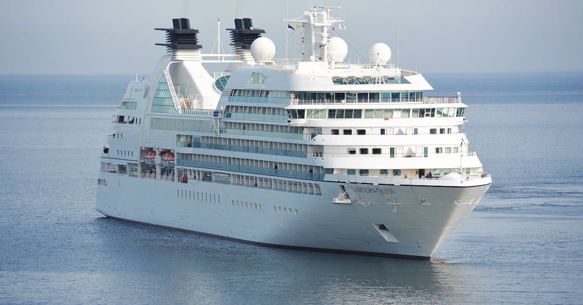 A large white cruise ship is floating on top of a body of water.