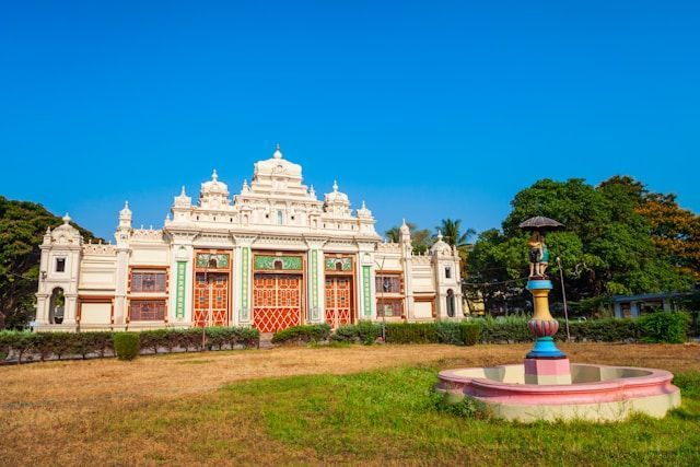 A large white building with a fountain in front of it.