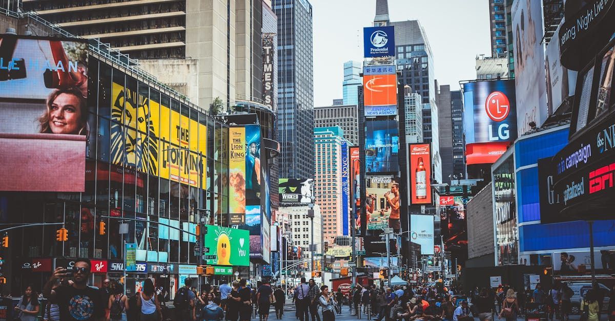 A crowd of people are walking down a busy city street.