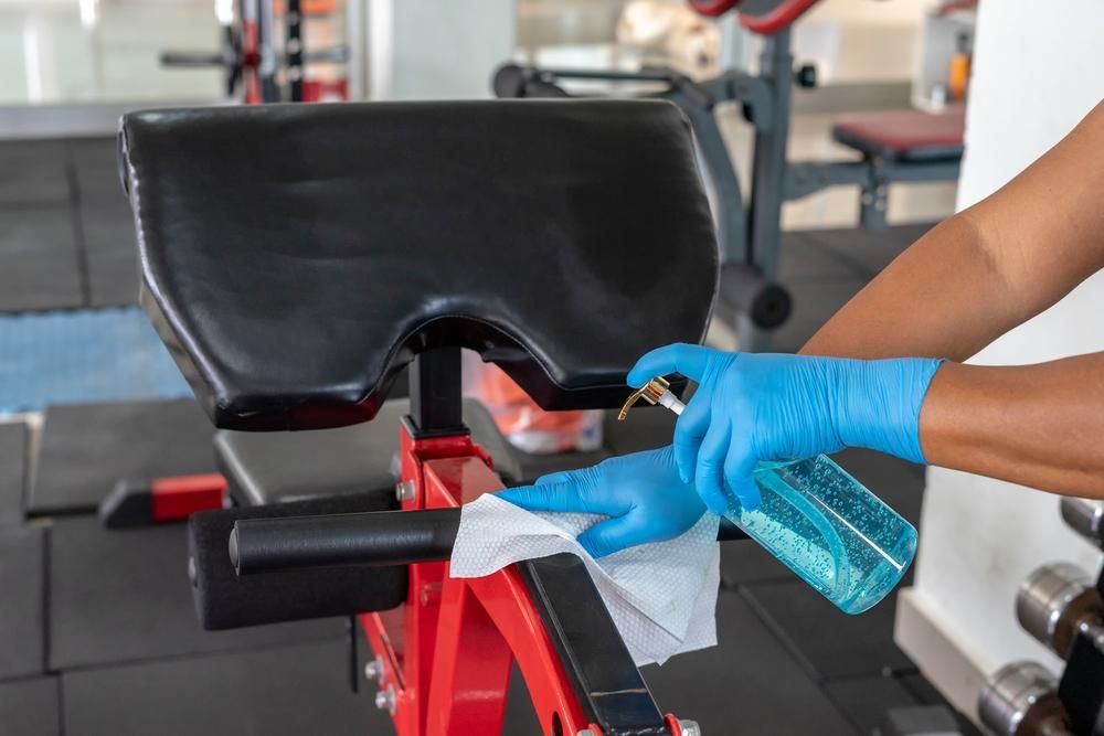 A Person Wearing Blue Gloves — Professional Cleaning Company in Childers, QLD
