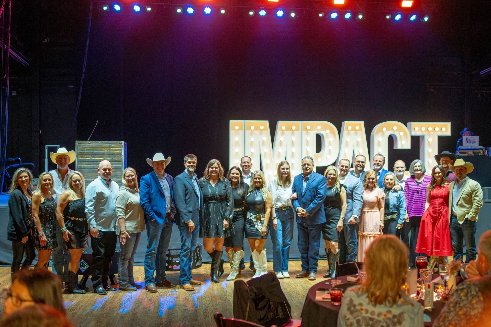 Group of people posing on stage in front of 